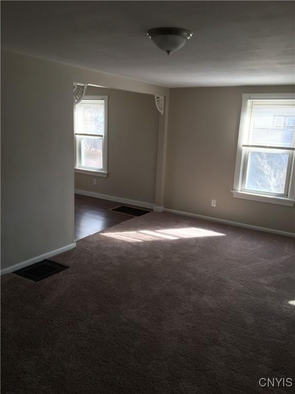 unfurnished room with dark carpet