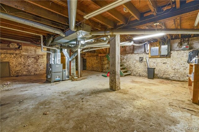 basement featuring heating unit and electric panel