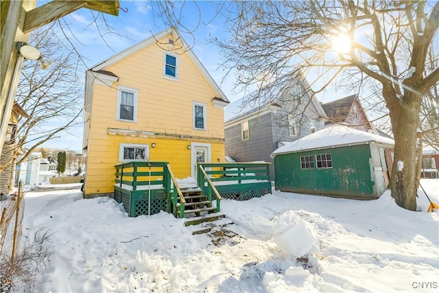 snow covered house with a wooden deck