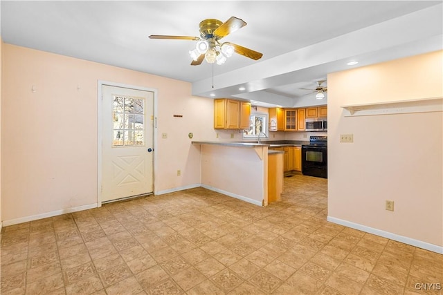 kitchen with black electric range oven, sink, a breakfast bar area, kitchen peninsula, and ceiling fan