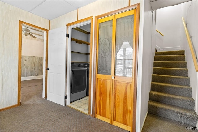 interior space featuring ceiling fan, light carpet, and wood walls