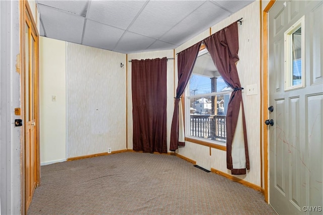 carpeted spare room with a drop ceiling