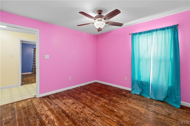 unfurnished room featuring dark wood-type flooring and ceiling fan