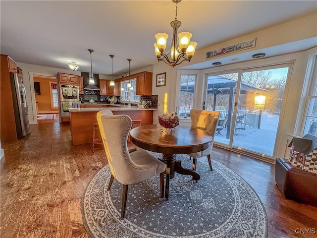 dining space with dark hardwood / wood-style floors and a chandelier