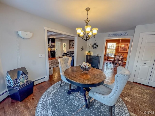 dining area with dark hardwood / wood-style floors, a chandelier, and baseboard heating