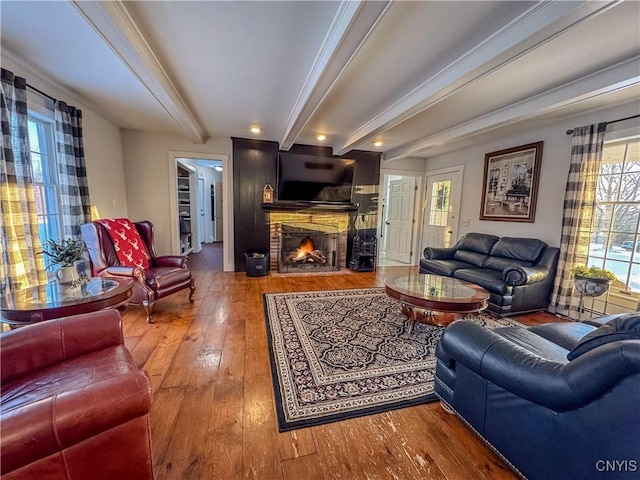 living room featuring beamed ceiling, crown molding, and hardwood / wood-style flooring