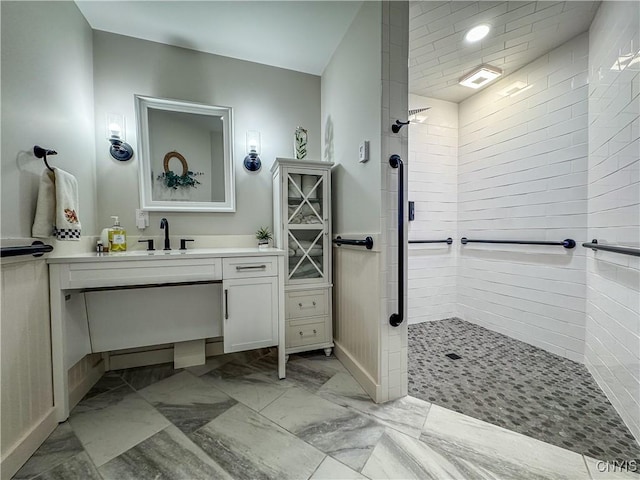 bathroom featuring vanity and tiled shower