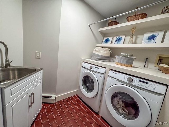 washroom with cabinets, sink, washer and dryer, and a baseboard heating unit