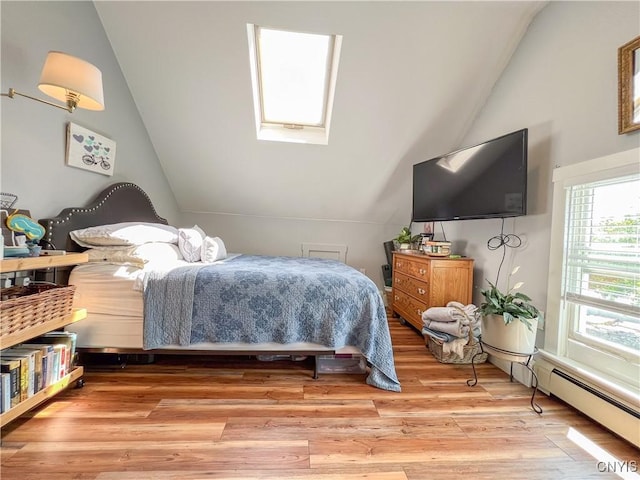 bedroom featuring lofted ceiling with skylight, baseboard heating, and light hardwood / wood-style flooring