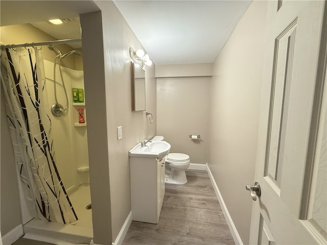 bathroom featuring vanity, wood-type flooring, toilet, and walk in shower