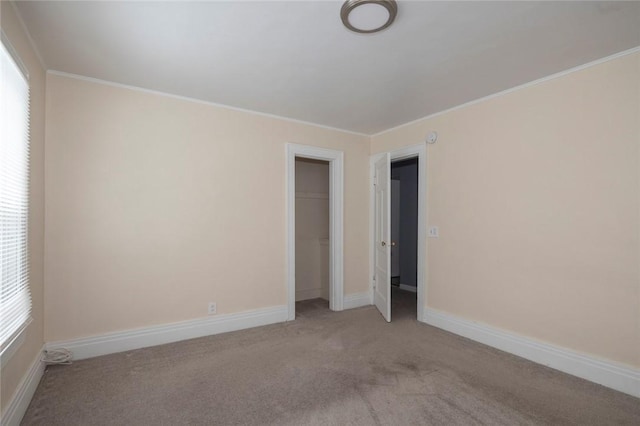 empty room featuring crown molding and light colored carpet