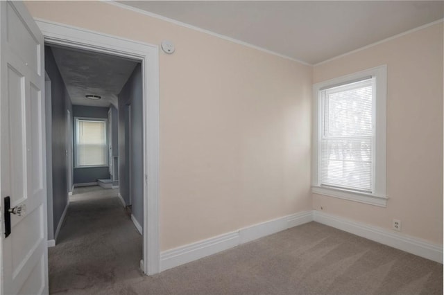 empty room featuring ornamental molding and dark carpet