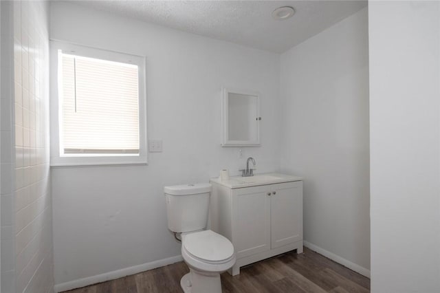 bathroom with vanity, a textured ceiling, wood-type flooring, and toilet