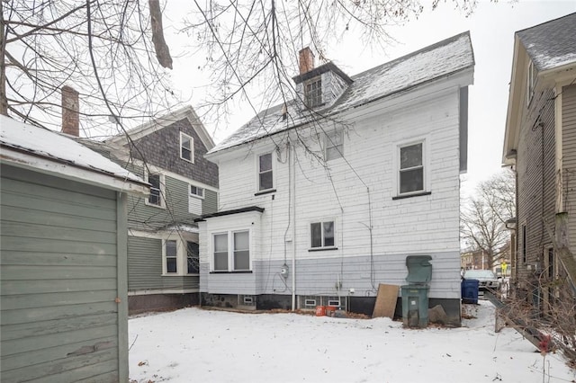 view of snow covered rear of property