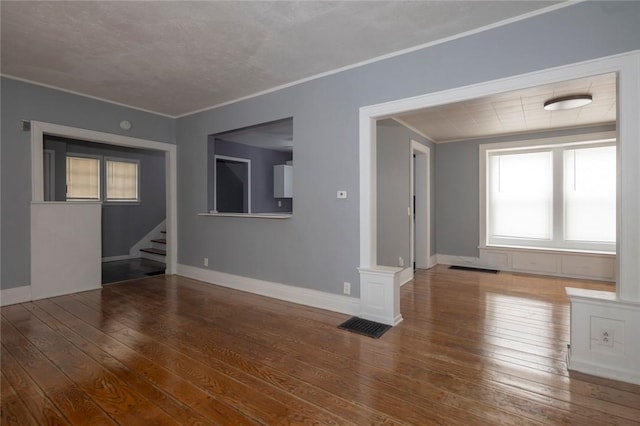 unfurnished living room featuring hardwood / wood-style flooring and ornamental molding