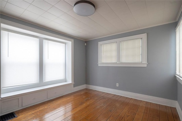 empty room featuring crown molding and light wood-type flooring