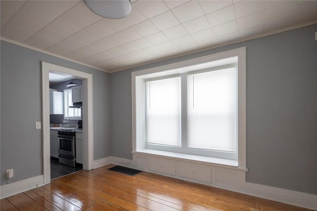 empty room featuring hardwood / wood-style flooring and ornamental molding