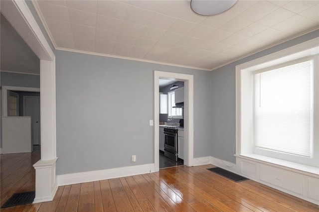 unfurnished living room with hardwood / wood-style flooring and ornamental molding