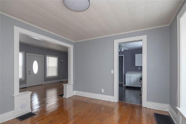 entrance foyer featuring hardwood / wood-style flooring, ornamental molding, and decorative columns