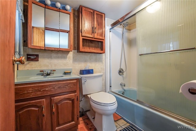 full bathroom with toilet, bath / shower combo with glass door, tile walls, vanity, and backsplash