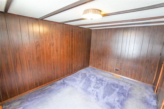 unfurnished room with dark carpet and wood walls