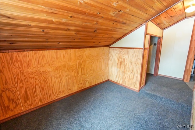 bonus room featuring vaulted ceiling, wooden walls, dark carpet, and wooden ceiling