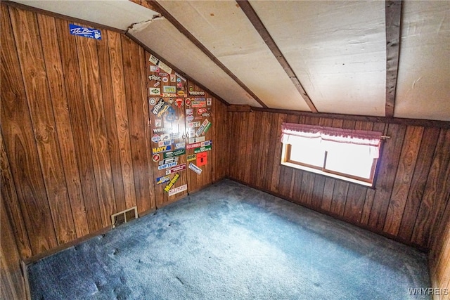 bonus room with vaulted ceiling, wooden walls, and dark carpet