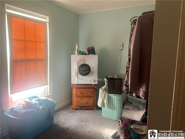 washroom with crown molding, stacked washing maching and dryer, and carpet