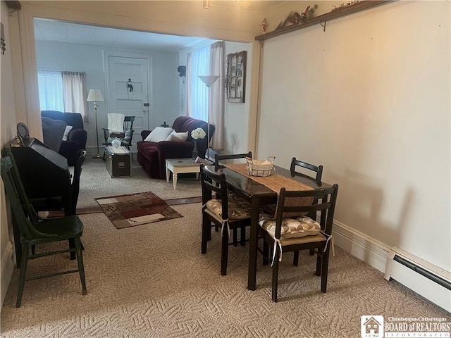 carpeted dining area with a baseboard heating unit