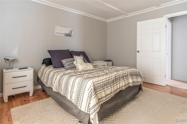 bedroom featuring crown molding and light hardwood / wood-style floors