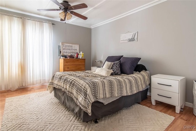 bedroom with crown molding, ceiling fan, and light hardwood / wood-style floors