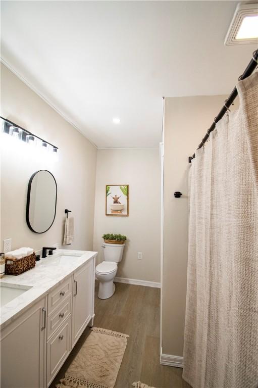 bathroom featuring wood-type flooring, toilet, and vanity