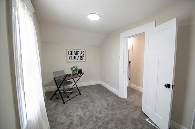 carpeted home office featuring vaulted ceiling