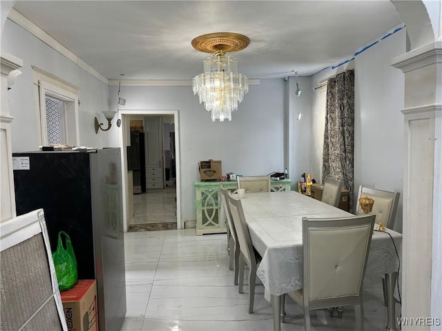 dining room featuring ornamental molding and an inviting chandelier