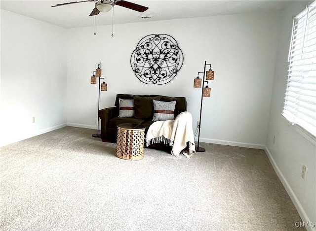 living area featuring carpet floors and ceiling fan