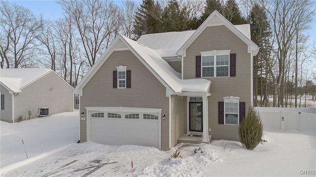 traditional home featuring a garage, fence, and central AC unit