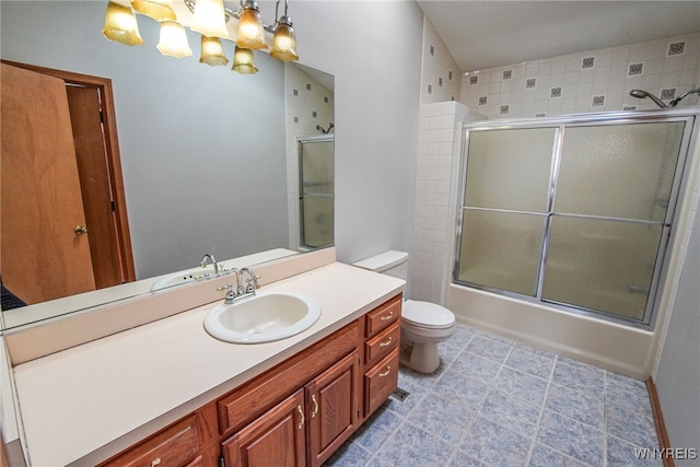 full bathroom featuring vanity, shower / bath combination with glass door, and toilet