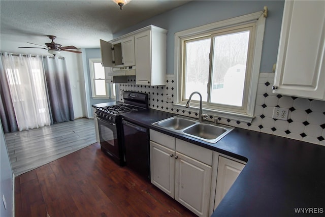 kitchen with sink, dark wood-type flooring, black appliances, white cabinets, and decorative backsplash