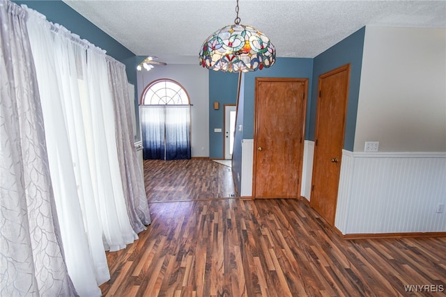 hall with a textured ceiling and dark hardwood / wood-style flooring