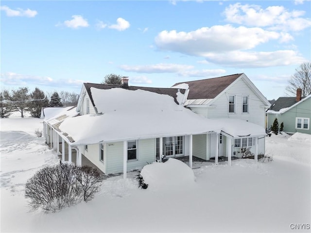 view of snow covered rear of property