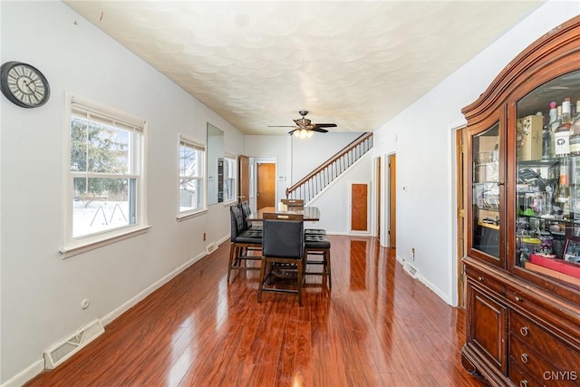 dining room featuring dark wood-type flooring, a textured ceiling, and ceiling fan