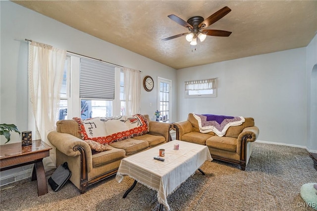 carpeted living room with ceiling fan and a textured ceiling