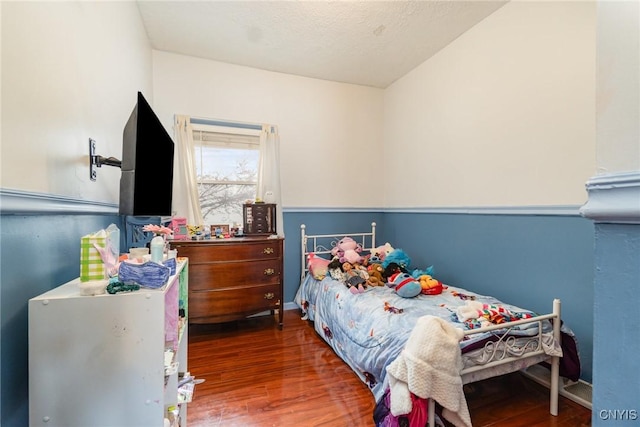 bedroom featuring a textured ceiling and dark hardwood / wood-style flooring