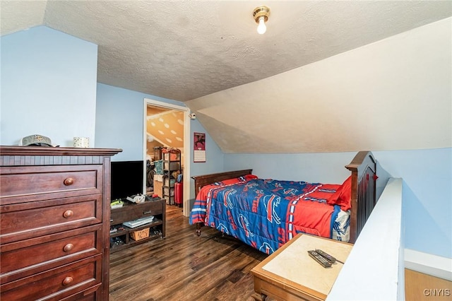 bedroom featuring dark wood-type flooring, lofted ceiling, and a textured ceiling