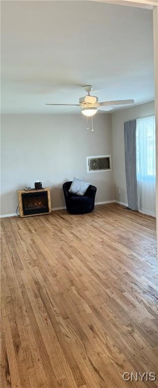 unfurnished room featuring baseboards, ceiling fan, and wood finished floors