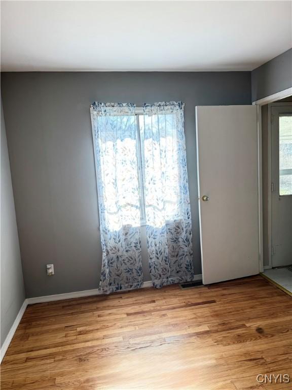 spare room featuring light wood-style flooring and baseboards