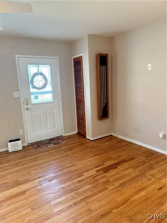 foyer entrance featuring baseboards and light wood-style floors