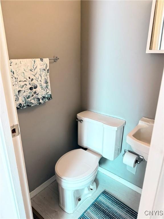 half bathroom featuring toilet and baseboards