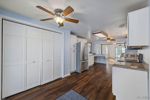 2202 River Rd, Wheatfield, NY 14304 - kitchen with freestanding refrigerator, ceiling fan, white cabinets, dark wood-style floors, and dark stone countertops