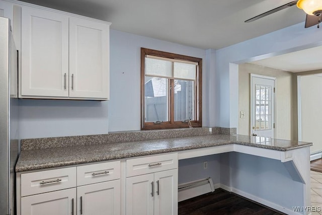 2202 River Rd, Wheatfield, NY 14304 - kitchen featuring a baseboard radiator, dark wood finished floors, white cabinetry, ceiling fan, and freestanding refrigerator